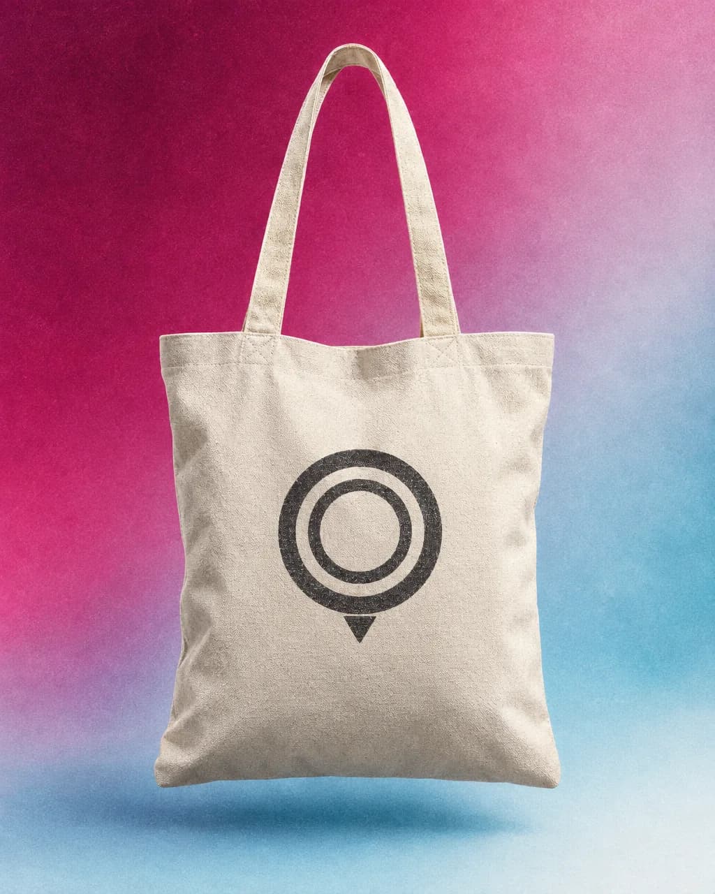 Natural canvas tote with a large nested-ring map-pin logo on a magenta-ice gradient