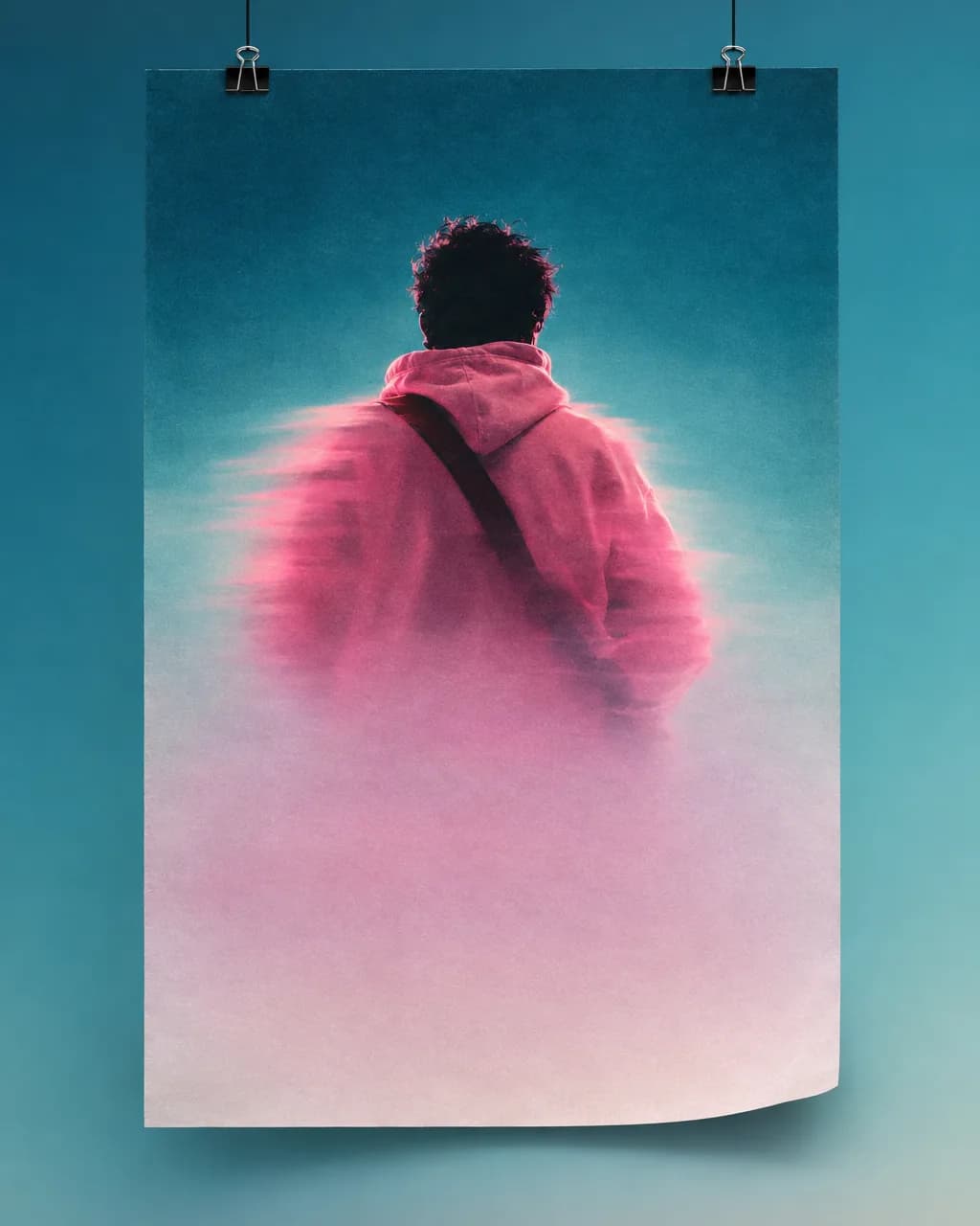 Concert poster hanging from binder clips showing a figure in a pink hoodie from behind