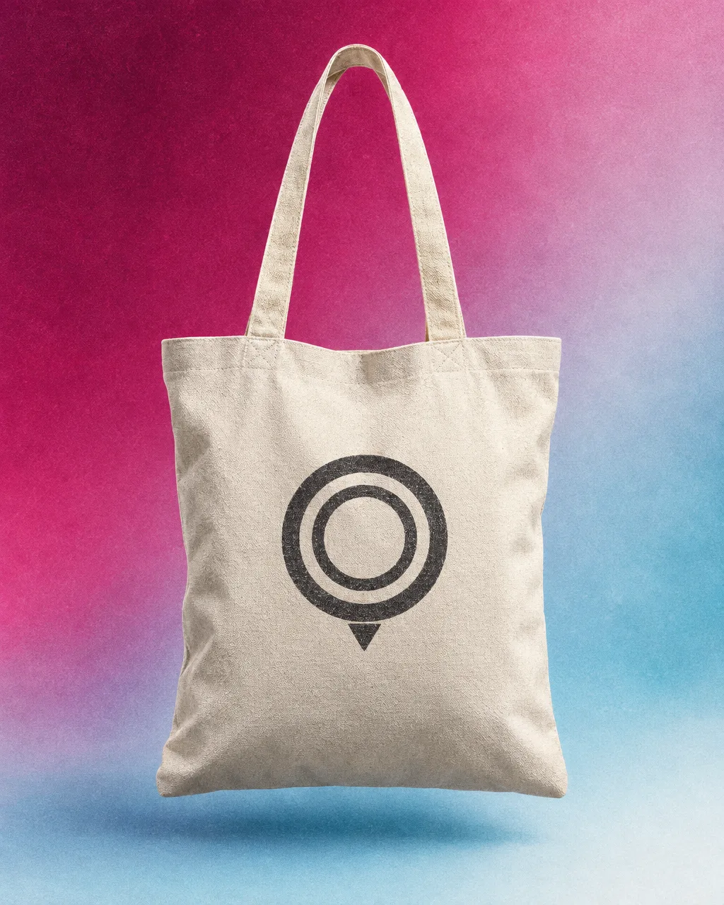 Natural canvas tote with a large nested-ring map-pin logo on a magenta-ice gradient