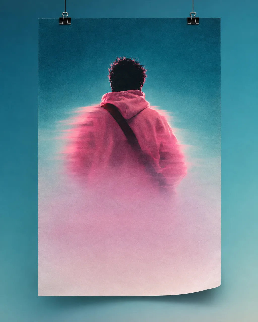 Concert poster hanging from binder clips showing a figure in a pink hoodie from behind